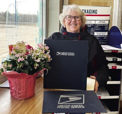 Val Percival stands with some of the awards and gifts received during her 30 years with the Oxford post office.