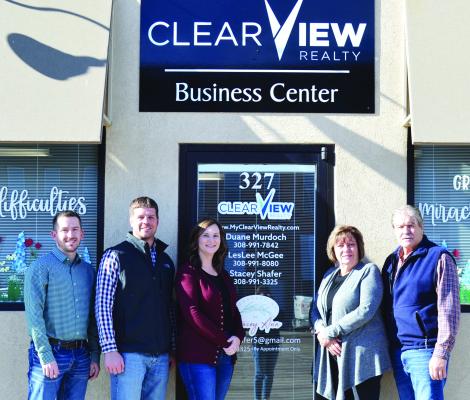Austin Davis (designated broker) and Colby Gray (owner) pictured with Stacy Shafer, LesLee McGee and Duane Murdoch in front of the Oxford office for Clear View Realty.