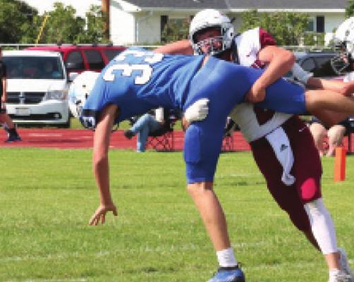 Hi-Line’s Colton Stubbs lifts and wrestles down a Bertrand receiver.
