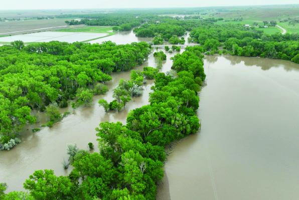 INDIANOLA - Friday, heavy rains across Dundy, Hitchcock, Chase, Hayes and Red Willow counties sent waters rushing to the Republican River, which swelled outside of its banks near Indianola as pictured above by drone images taken by Reid Stagemeyer. Local reports of nine or ten inches of rain fell Friday in areas west and south of McCook and chances of further rain exist almost daily over the next week.