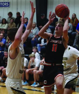 Cambridge senior Carson Trompke puts up a running shot over a defender.