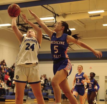 Arapahoe’s Clara Hilker tries for a layup while Medicine Valley’s Kamree Elsten tries for a block.