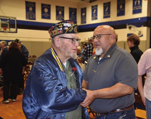 Veterans Lee Carskadon and Rudy Perez shake hands after the Veterans Day program that was put on by the Arapahoe/ Holbrook FCCLA Chapter
