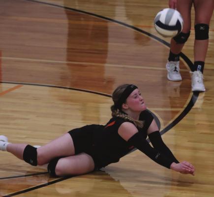 Cambridge’s Bailee Ahlemeyer dives for a dig against Alma