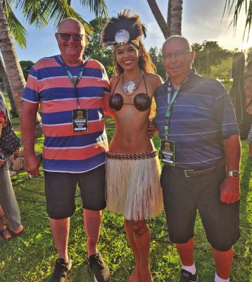 Richard Wilson(left) and Dennis Troester pose with a performer at the Luau they attended while in Honolulu, Hawaii.