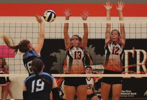 Cambridge’s Schyler Hoberty and Erin Johnson combine to block Southwest’s Payton Truksa during Saturday’s Championship at the Cambridge volleyball tournament.