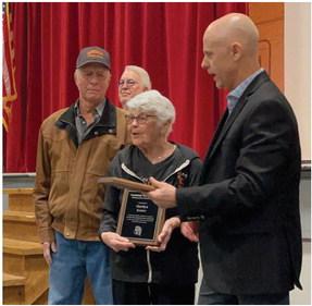 Cambridge teacher Adam Cribelli presents Distinguished Alumni plaques to Ed and Marilyn Kester Friday.