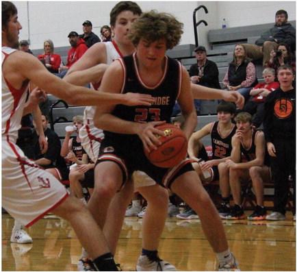 Trojan Braydon Miller makes contact in the paint with players from Sutherland at last Friday’s game.