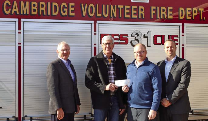 Waypoint Bank CEO Kirk Riley (left) Tim Sladek , Nebraska Market President (right) and Cambridge Branch President, Derek Downer (center-right) present the check for $25,000 to Cambridge Volunteer Fire Department Fire Chief, Delaine Soucie (center-left).