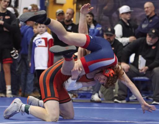 Cambridge’s Micah Gerlach, who took first at 150, takes his opponent to his back during his 100th career win Saturday.