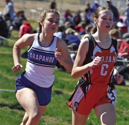 Cambridge’s Lydia McGowen, pictured alongside Arapahoe’s Grace Andrews, nearly broke the school record in winning the 1,600 run at Hi-Line Thursday. She then shattered the record Tuesday at the DCS Invite with a time of 5:24