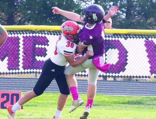 Cambridge’s Hunter Perks lands a crushing blow to Neligh-Oakdale quarterback Aiden Kuester.