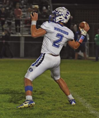 Arapahoe’s Kade Fisher launches a touchdown pass to Alex Diaz.
