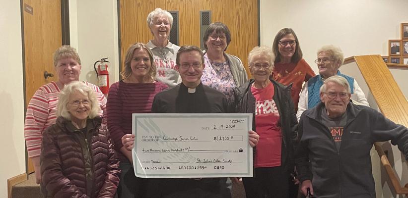 Father Kenneth Wehrs and members of the St. John’s Catholic Church Altar Society presents a check for $2,700 to members of the Cambridge Senior Center. The proceeds are from the pancake supper held at St. John’s.