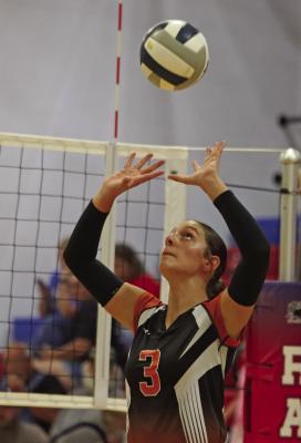 The Trojans’ Mallory Springer sets a teammate.