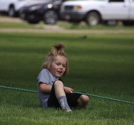 A kid tries hard to regain control of the rope during his round of tug-of-war.