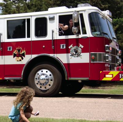 A child collects candy as it is thrown from a person in the Bartley Fire Department firetruck engine.