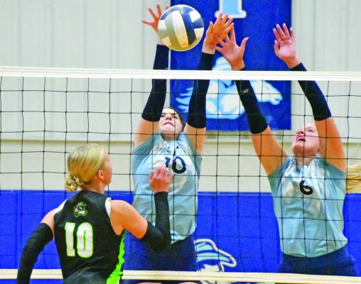 The Roughriders’ Aspen Billeter and Kyra Nelms block back an MHC attack Thursday.