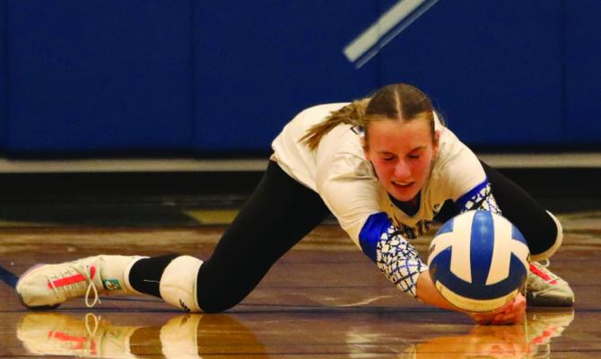 Arapahoe’s Desi Farner dives for a serve reception.