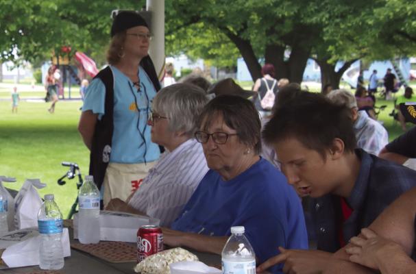 Enjoying drinks and popcorn, people of Bartley play bingo in the park, led by volunteers from Stockman’s Bank.