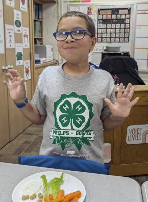 Colten Nation, Elwood Public School fourth grader, enjoying food presented during 4-H Healthy Habits.