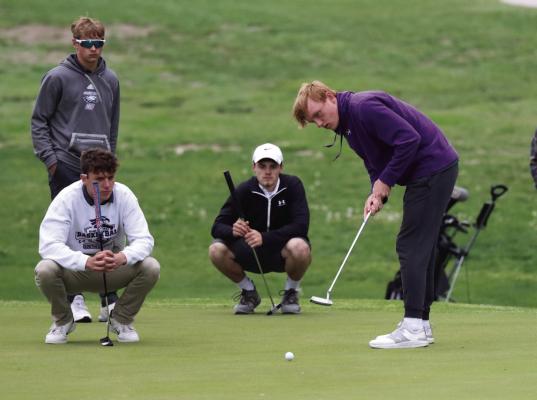 Southern Valley’s Rian Grove attempts a putt while members of the Hitchcock County and Southern Valley teams look on during the two teams’ playoff for the final spot at State.