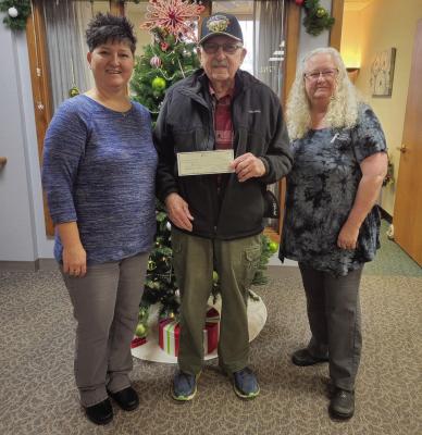 First Cental Bank employees in Arapahoe paid $10 per month to wear jeans on Fridays, then matched these funds and donated the money to the Arapahoe Food Pantry. Pictured is Jennifer Schroeder and Loi Moore giving a check to Howard Davis, the president of the Arapahoe Food Pantry.
