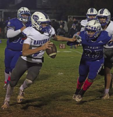 Arapahoe’s Eli Shafer and Jacen Smith close in on the Ravenna quarterback.