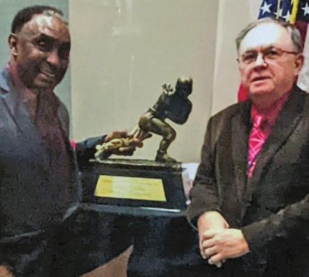 Outgoing Furnas County Clerk Kennis McClelland is pictured with one of his heroes, Johnny Rodgers, whom he introduced at the 2019 State Convention of County Officials