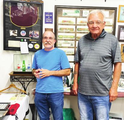 Gary Schroeder (right) stands with Chris Weide (left) next to a rare collection of bottles displayed at the Museum of Oxford last Wednesday, August 25. Weide stopped at the museum specifically to see the bottles.