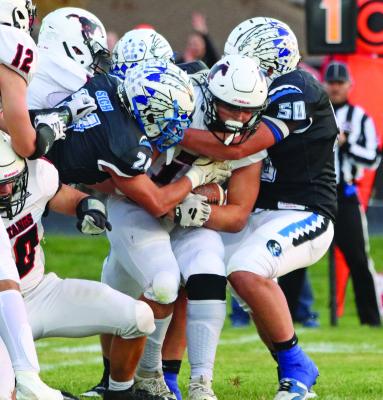 The Warriors’ Trey Downey and Hayden Sich combine to stop the Sutton runner in his tracks.