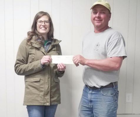 Harlan/Furnas County Farm Bureau Federation Board Member -- Nick Holste -- is shown presenting a Donation Check for the Furnas County 4-H Council to Extension Educator Elena Stout, during April's Farm Bureau Board Meeting.