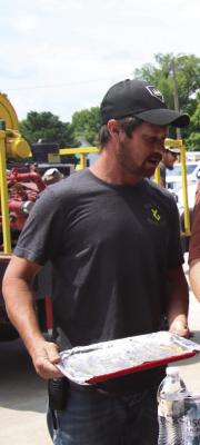 A member of the Bartley Fire Department and EMS prepares to transfer burgers.