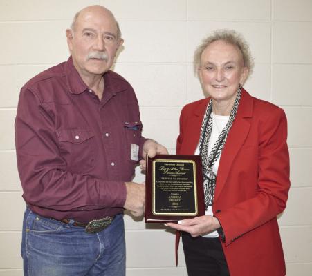 Nebraska Sheep and Goat Producers Association President Daniel Stehlik of Curtis presents the 13th Annual Ted and Alice Doane Service Award to Andrea Nisley of Elwood for her many years of work with the Make It With Wool Contests. The plaque was awarded at a recent NSGPA conference and annual meeting.