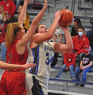 Arapahoe’s Hope Koller is fouled while trying to score inside.