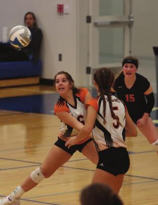 The Trojans’ Carson Hanes digs a ball in the back row.
