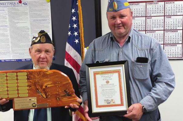 Pictured L-R: Lee Carskadon holding the traveling plaque and Arlan Leising holding framed certificate.