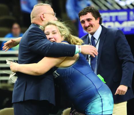 Southwest’s Madelyn Tryon celebrates a state title with coaches Jay Helberg and Dillon Fries.