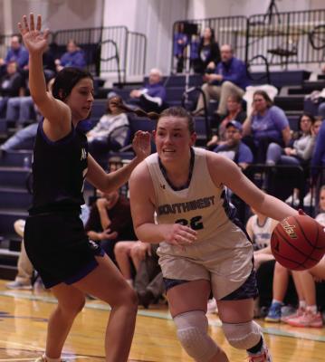 Southwest’s Caylin Barnett drives to the hoop around the defense of Sabrina Jacobsen.