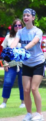 A cheerleader from Southwest Public Schools performs the dance to the first song played by the Southwest Marching Band.