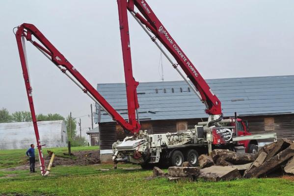 A boom truck helps pour concrete footings for the west wing of the Bartley Sales Pavilion.