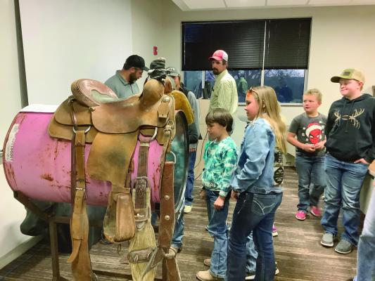 These young kids are learning how to solve saddle issues during the 4-H Horsemanship Workshop