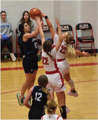 Arapahoe’s Sabrina Jacobsen pulls up for a jumper with a pair of Alma defenders in her face.