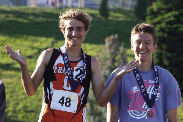 Trojans Carson Trompke, alongside Medicine Valley’s Kael Garrett, receives his medal from the 3,200 meter run.