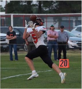 The Trojans’ Tate Koeppen (above) and Hodge Raburn (below) haul in touchdown receptions.