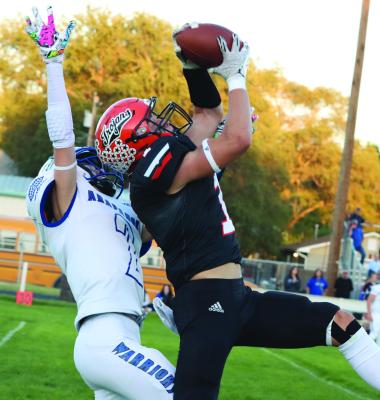 Cambridge’s Kohan Grindle high-points a reception in the first half against Arapahoe.