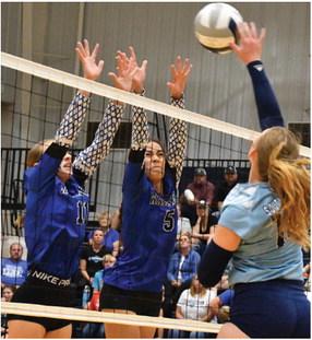 Arapahoe’s Grace Andrews and Naomi Gutierrez rise to block Southwest’s Atleigh Nelms.