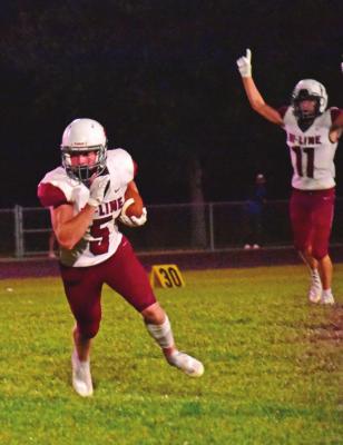 Hi-Line’s Cooper Ray escapes on a touchdown run while Ryker Evans celebrates the inevitable in the background.