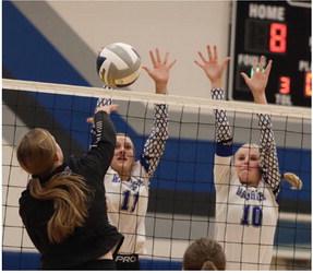 Arapahoe’s Desi Farner and Emma Strand rise for a block against the Falcons Thursday.