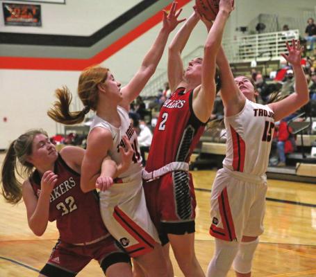 Cambridge’s Autumn Deterding and Carsyn Hanes battle a pair of Caoxad players for a rebound Thursday.